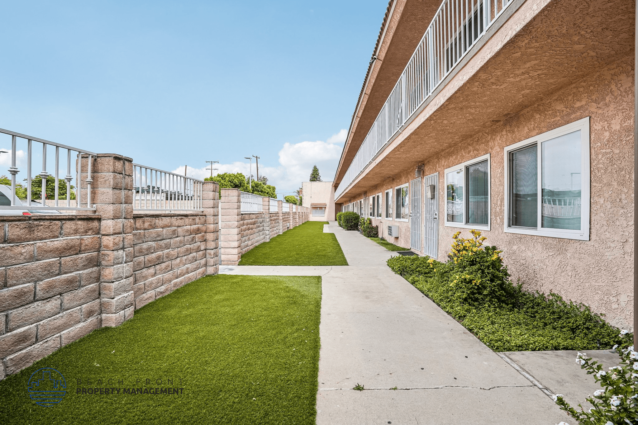 A long concrete walkway leads between two rows of houses.,A long concrete walkway leads between two rows of houses.